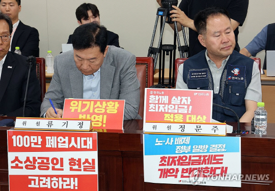 10일 정부세종청사에서 열린 최저임금위원회 제4차 전원회의에서최저임금위원회 사용자위원인 류기정 한국경영자총협회 전무(왼쪽)와 근로자위원 정문주 한국노총 중앙연구원장이 착석해 있다. 연합뉴스